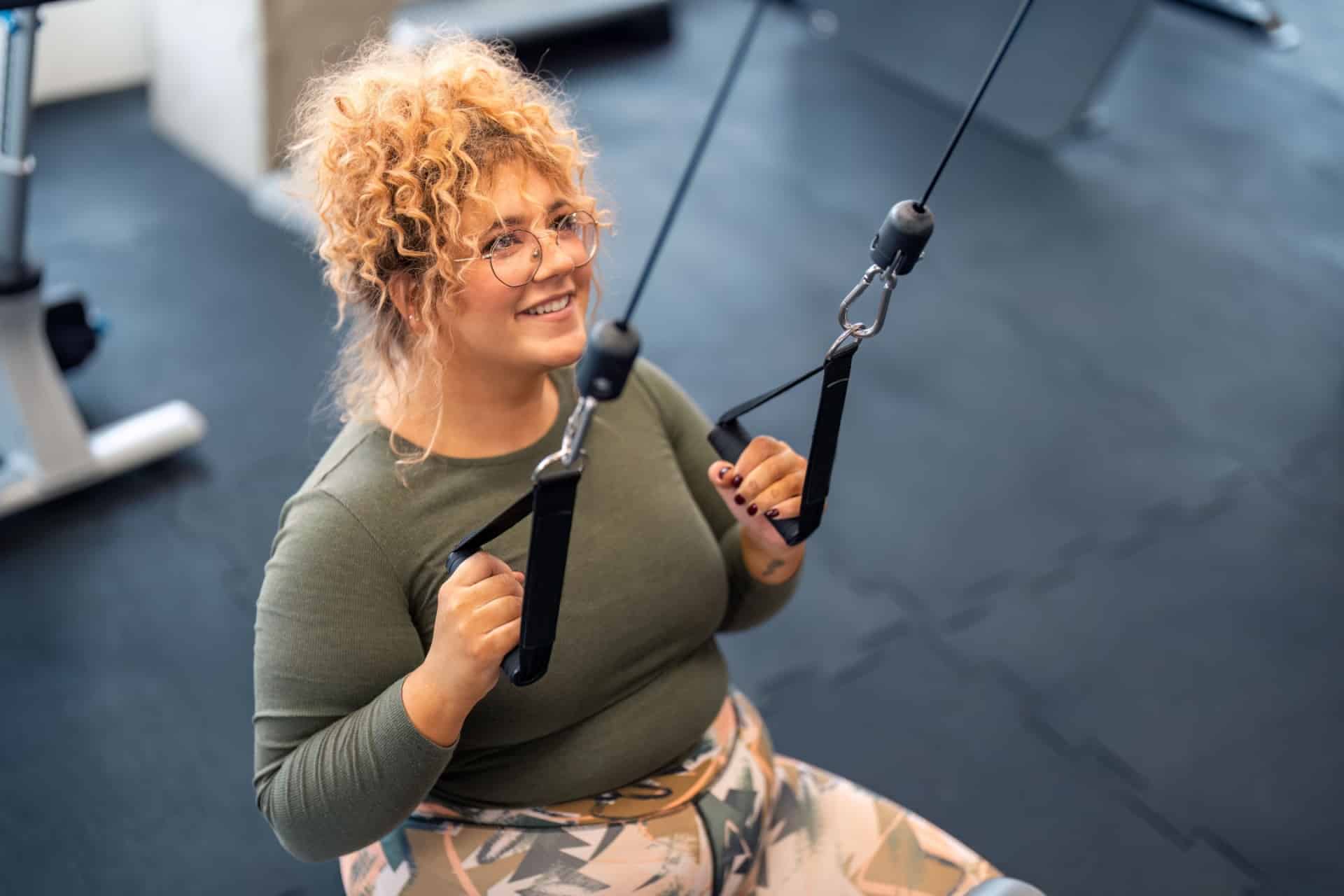 Ung kvinne som trenger på treningssenter